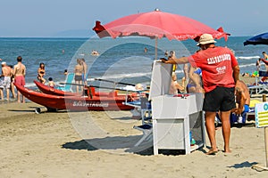 Beach lifeguard surrounded by resting people in Viareggio, Italy