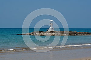 beach with a lightouse on an island