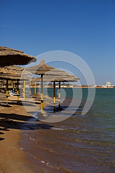 Beach line with straw umbrellas by the red sea in Hurghada