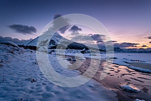 Beach on the Lofoten islands, Norway. Mountains, beach and clouds during sunset. Evening time. Winter landscape near the ocean.