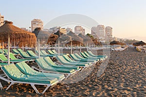 Beach lounge chair and beach umbrella at lonely sandy beach