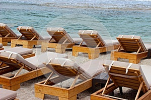 Beach lounge chairs empty with sea