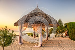 Beach lounge chairs at sunset, Zanzibar, Tanzania