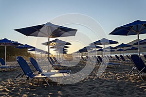 Beach lounge chairs under umbrellas on the seashore