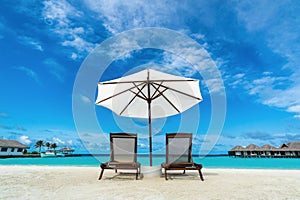 Beach lounger and umbrella on sand beach.