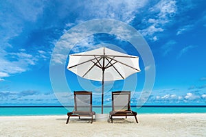 Beach lounger and umbrella on sand beach. Concept for rest, relaxation, holidays, spa, resort.