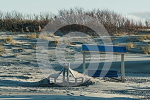 Beach loungers covered with sea sand await summer heat