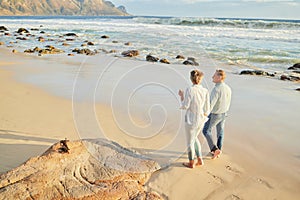 Beach, love and a senior couple walking on the sand by the ocean or sea for romance or dating at sunset. Nature, summer