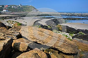 The beach at low tide with colorful rocks in the foreground at Cap Gris Nez, Cote d`Opale, Pas de Calais, Hauts de France, France