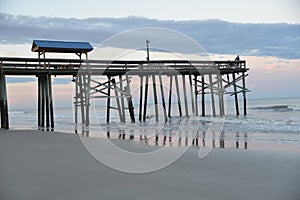 The beach at low-tide extends over a sandy floor with tidal pools next to the waterline