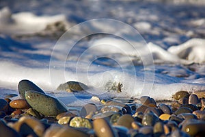 Sea rolling and receding water in rays of setting sun.