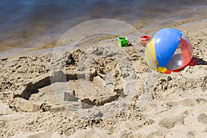 On the beach near the water, built a sand castle and lie ball and children`s buckets.