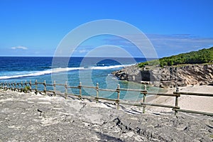 A beach nearby the famous Trou dArgent at Rodrigues Island taken from top with visible safety wooden barrier