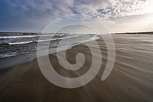 Beach and north sea on a stormy sunny day on Ameland, the Netherlands