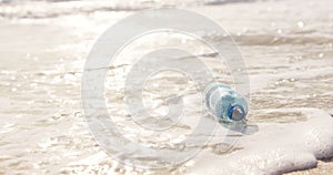 Beach, ocean and plastic bottle in sand for pollution, litter and trash in sea for global warming crisis. Nature