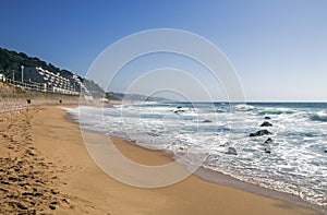 Beach Ocean Waves and Shoreline Against Blue Sky