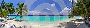 Beach panorama at Maldives with blue sky, palm trees and turquoise water