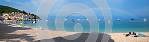Beach panorama Moscenicka Draga, adriatic ocean with boats, rainbow over the water photo