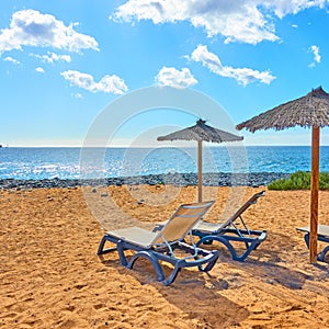 Beach with parasol and chaise longues photo