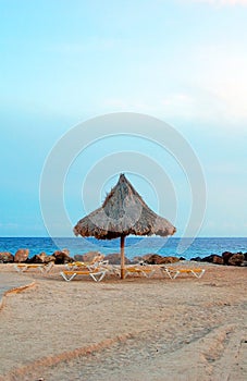 Beach with parasol and sun beds in the evening