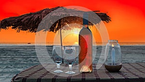 Beach party in cafe with bottle of rose wine and glasses at sunset, GOA, India