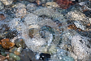 Beach pebbles under clear water