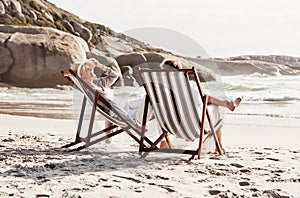 The beach is the perfect place for relaxation. Full length shot of an affectionate middle aged couple relaxing on