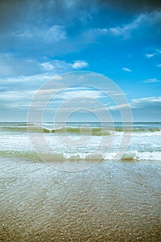 Beach photography - blue ocean waves, sand, overcast sky