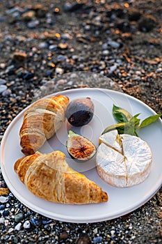 Beach picnic with figs, cheese and croissants