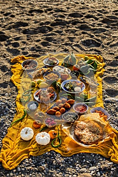 Beach picnic with turkish dishes on a yellow blanket