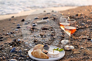 Beach picnic with wine, cheese and croissants