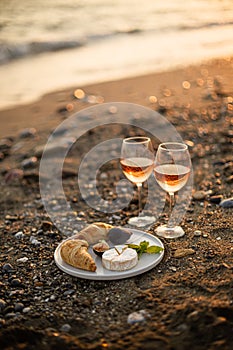 Beach picnic with wine, cheese and croissants