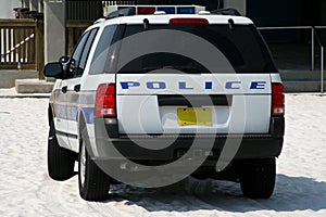 Beach police car parked on sandy beach