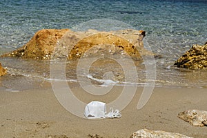 Beach polluted with face mask of covid. Environmental contamination problem