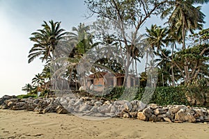 Beach poor huts, shacks among palm trees at tropical sunrise, Cabarete, Dominican Repiblic