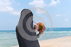 beach profile girl drinking a coconut fresh cocktail in tropical sea photo