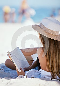 Beach, reading a book and woman relax, summer vacation and getaway on a weekend break, peace and sand. Female person