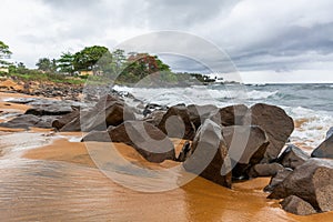 Beach with red sand and red rocks with a dramatic sky in Congo T photo