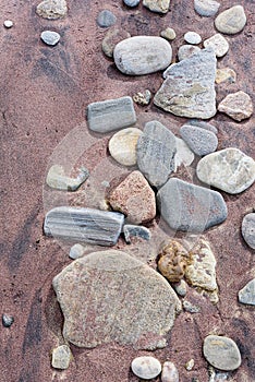 Beach red and yellow sand and sea stones