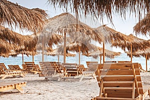 Beach with reed umbrellas and sunbeds