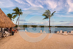 Beach resort and palm trees at sunset on a tropical island