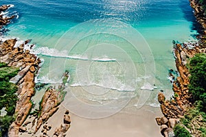 Beach, rocks and blue ocean in Brazil. Aerial view of tropical beach in Florianopolis