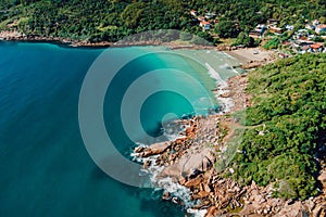 Beach, rocks and blue ocean in Brazil. Aerial view of tropical beach in Florianopolis