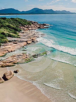 Beach with rocks and blue ocean in Brazil. Aerial view of tropical beach in Florianopolis photo