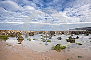 Beach with rocks in the sand at Cayton Bay, UK