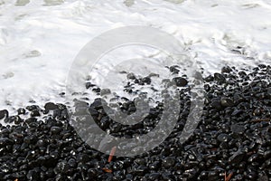 Beach rocks in sea foam