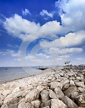 Beach With Rocks On And Small Hut