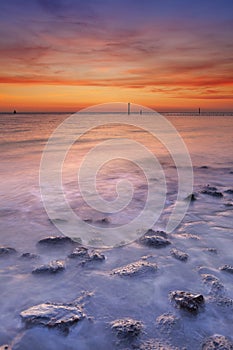 Beach with rocks at sunset in Zeeland, The Netherlands