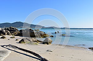 Beach with rocks and transparent water with turquoise colour and blue sky. Carnota, Galicia, Spain. photo