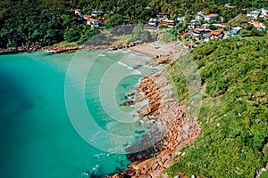 Beach, rocky coastline and transparent ocean in Brazil. Drone view of tropical beach in Florianopolis